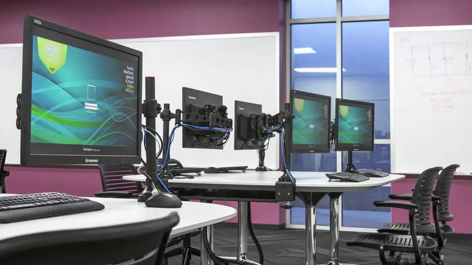 A desk with a computer monitor sitting on top of a table