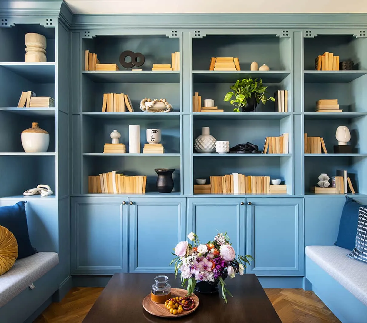 Un salón lleno de muebles y un jarrón de flores sobre una mesa