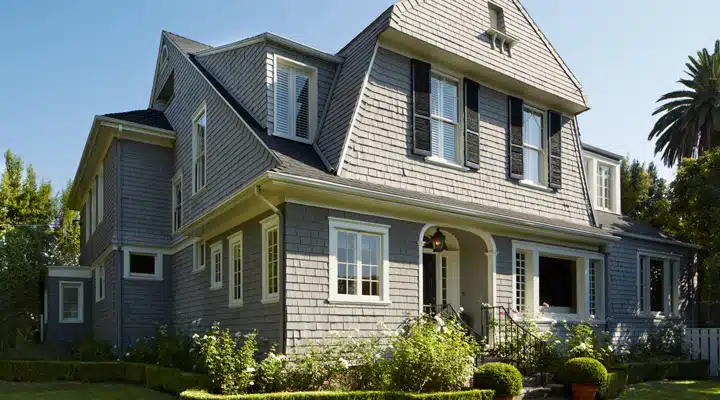 A house with bushes in front of a brick building