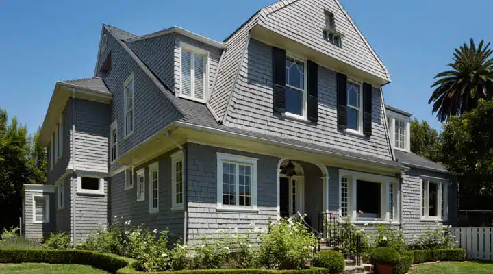 A house with bushes in front of a brick building