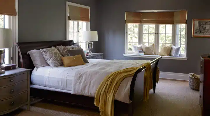 A bedroom with a bed and desk in a hotel room