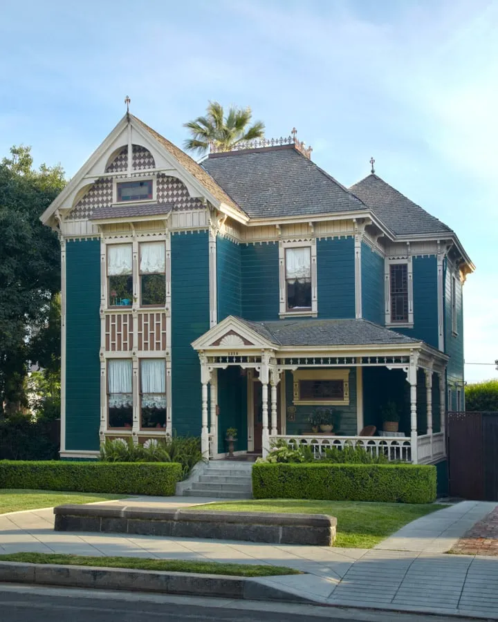 A small clock tower in front of a house