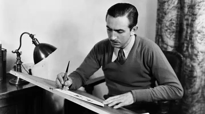 Walt Disney sitting at a table with a knife