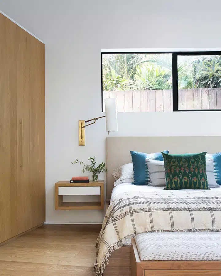 A bedroom with a bed and desk in a room