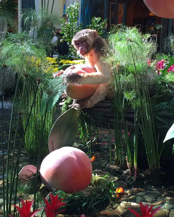 A person sitting at a table with a vase of flowers on a plant