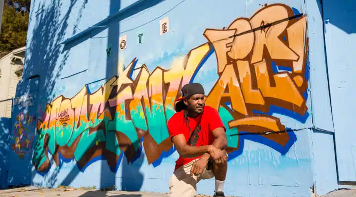 A man with graffiti on the side of a building