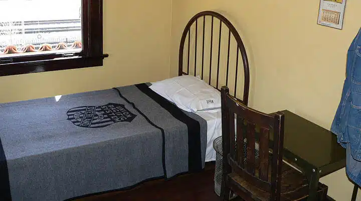 A bedroom with a bed and a chair in a room