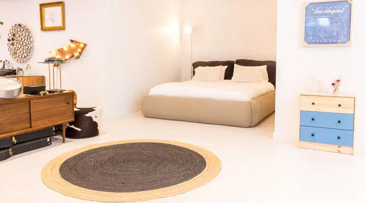 A bedroom with a bed and desk in a room