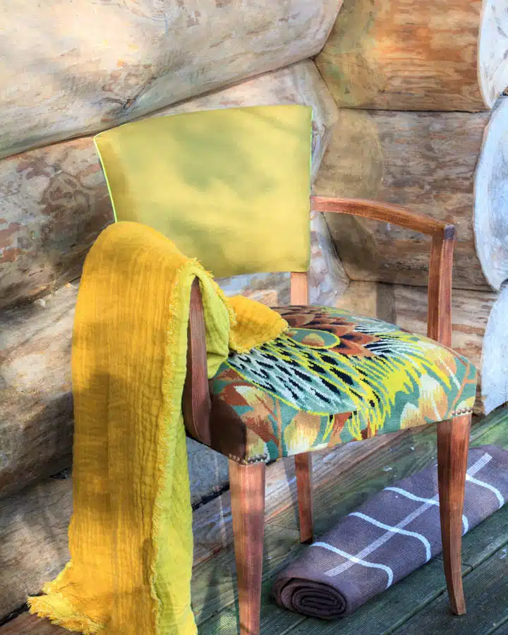 A cat lying on top of a wooden chair