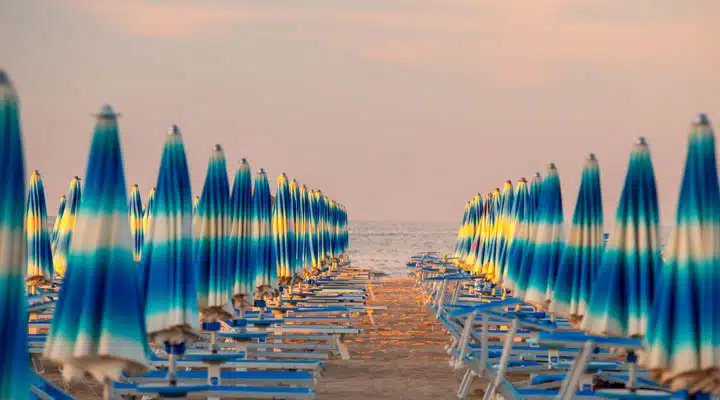 A group of lawn chairs sitting on top of a sandy beach