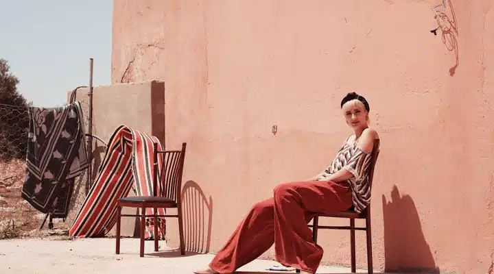 A person sitting on a chair in front of a building