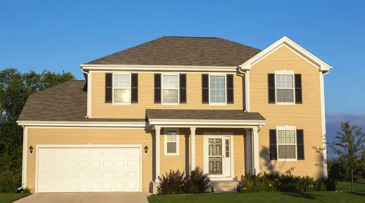 A large brick building with grass in front of a house