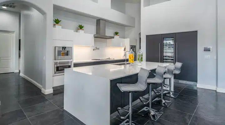 A kitchen with a refrigerator and table in a room