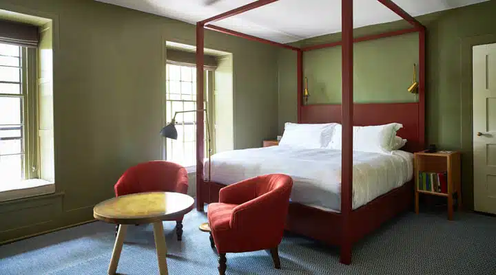 A bedroom with a bed and a chair in a room