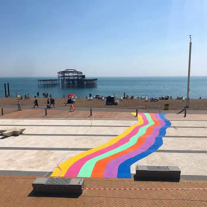 A colorful kite sitting on top of a sandy beach