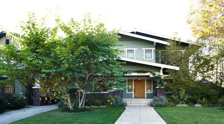 A house with a lawn in front of a brick building