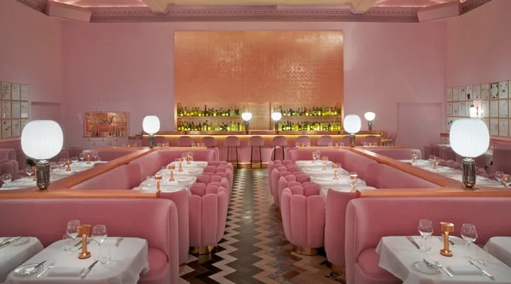 A row of pink flowers on a table next to a sink