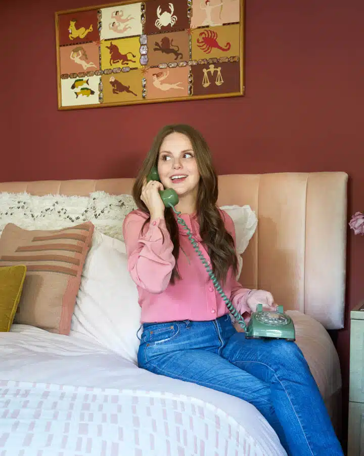 A woman sitting on a bed posing for the camera