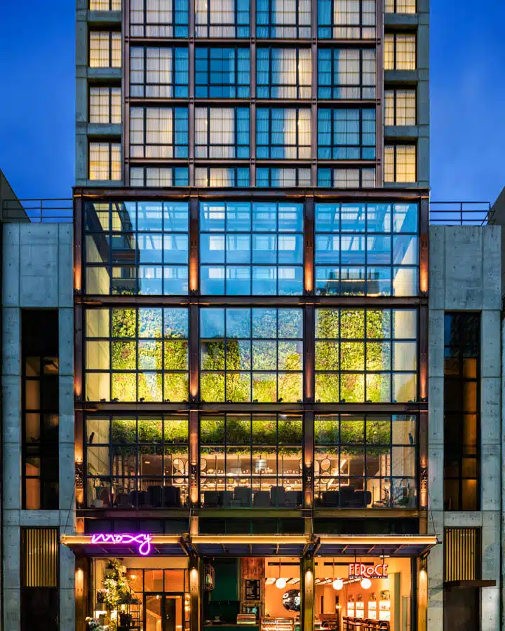 A tall glass building next to a window