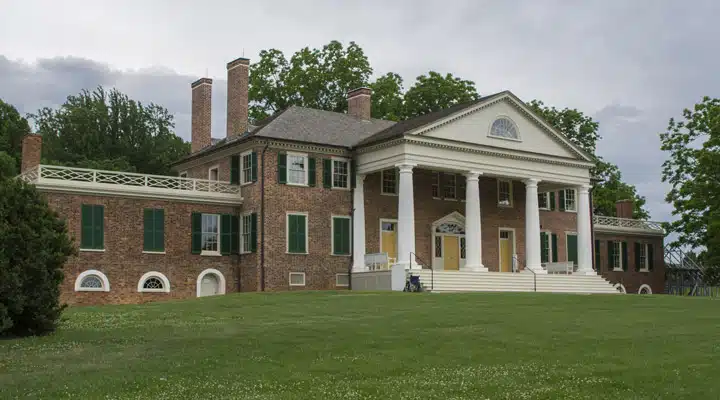 A large brick building with grass in front of a house