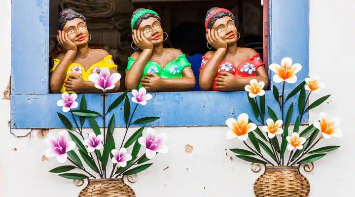 A group of people sitting at a table with a vase of colorful flowers