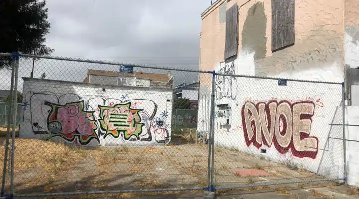 A stop sign with graffiti on the side of a building