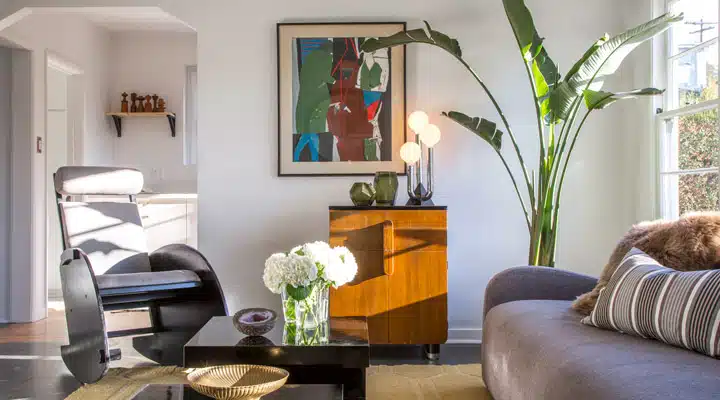 A living room filled with furniture and vase of flowers on a table