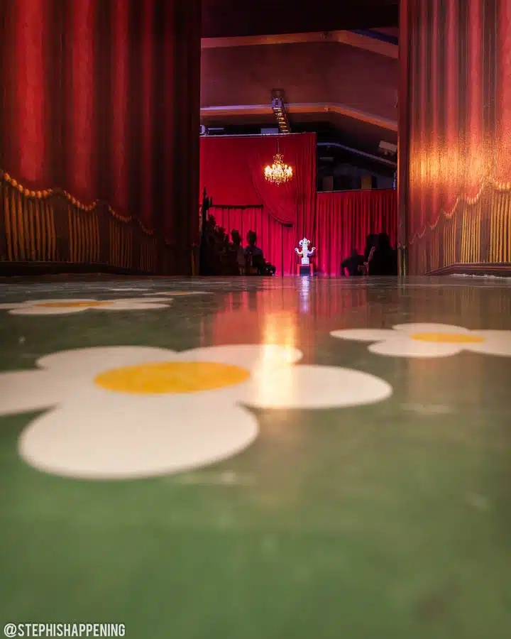 A room with a table in front of a curtain