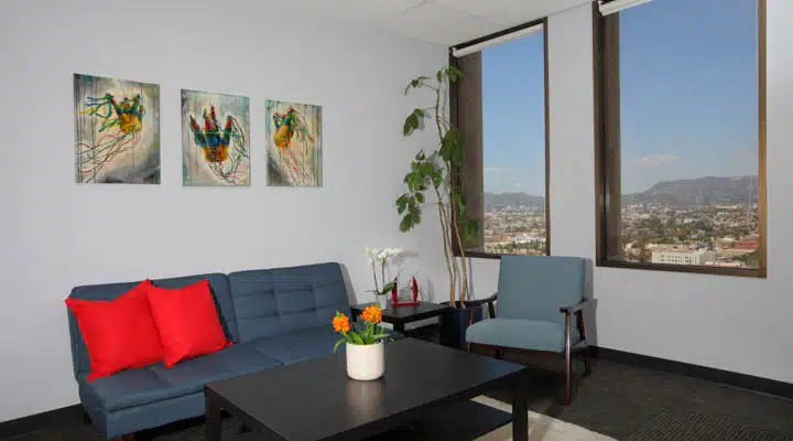 A view of a living room filled with furniture and a large window