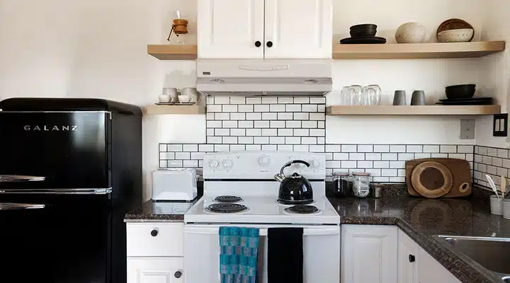 A kitchen with a stove a sink and a microwave