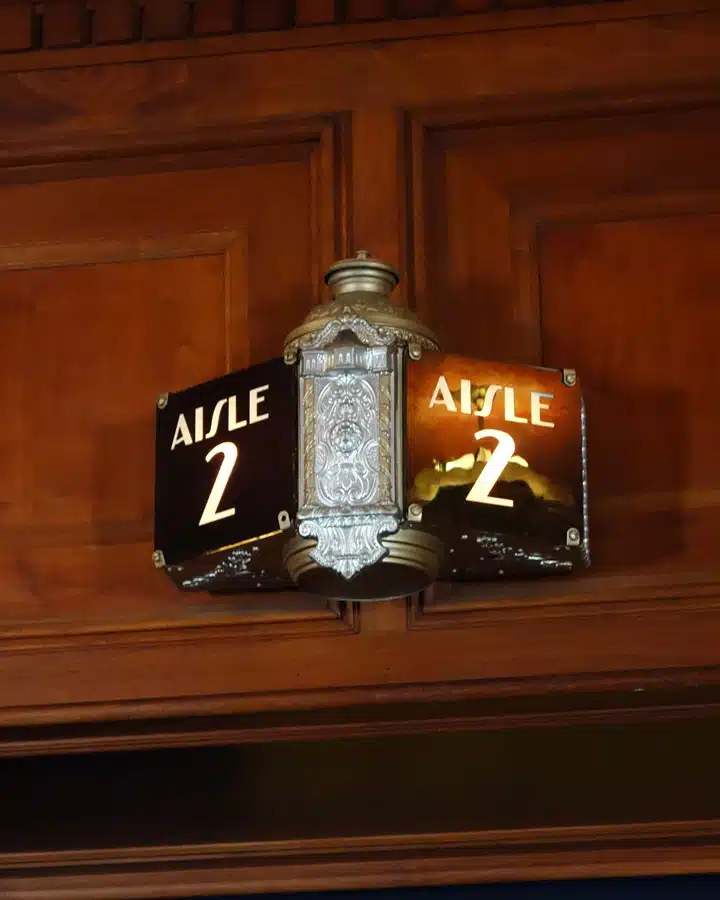 A wooden clock with the television on