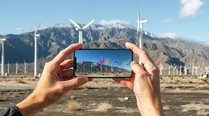A hand holding up a mountain in the background