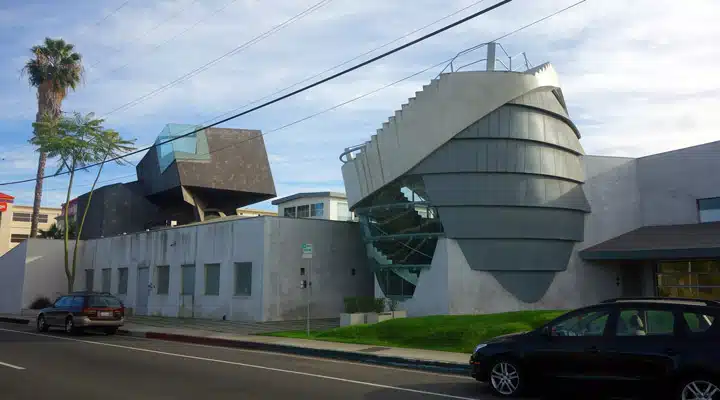 A car driving down a street next to a building