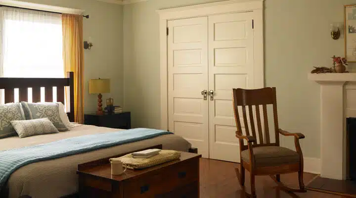 A bedroom with a bed and a chair in a room