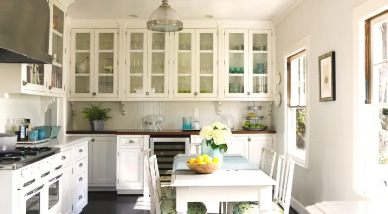 A room filled with furniture and vase of flowers on a kitchen counter
