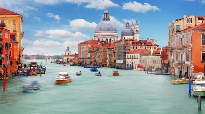 A small boat in a harbor with Grand Canal in the background