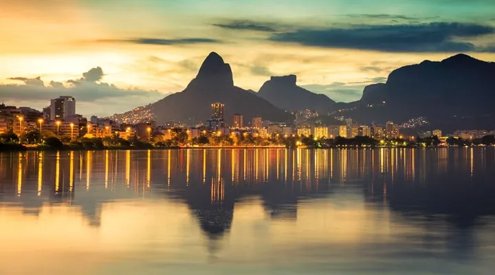 A sunset over a body of water with a city in the background