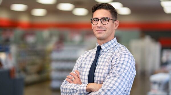 A man wearing glasses and smiling at the camera