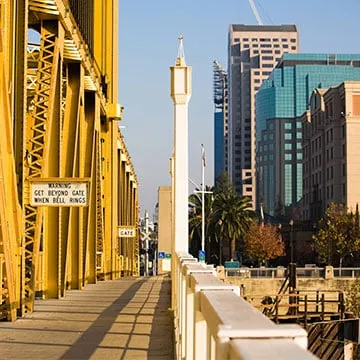 A bridge over water with a city in the background