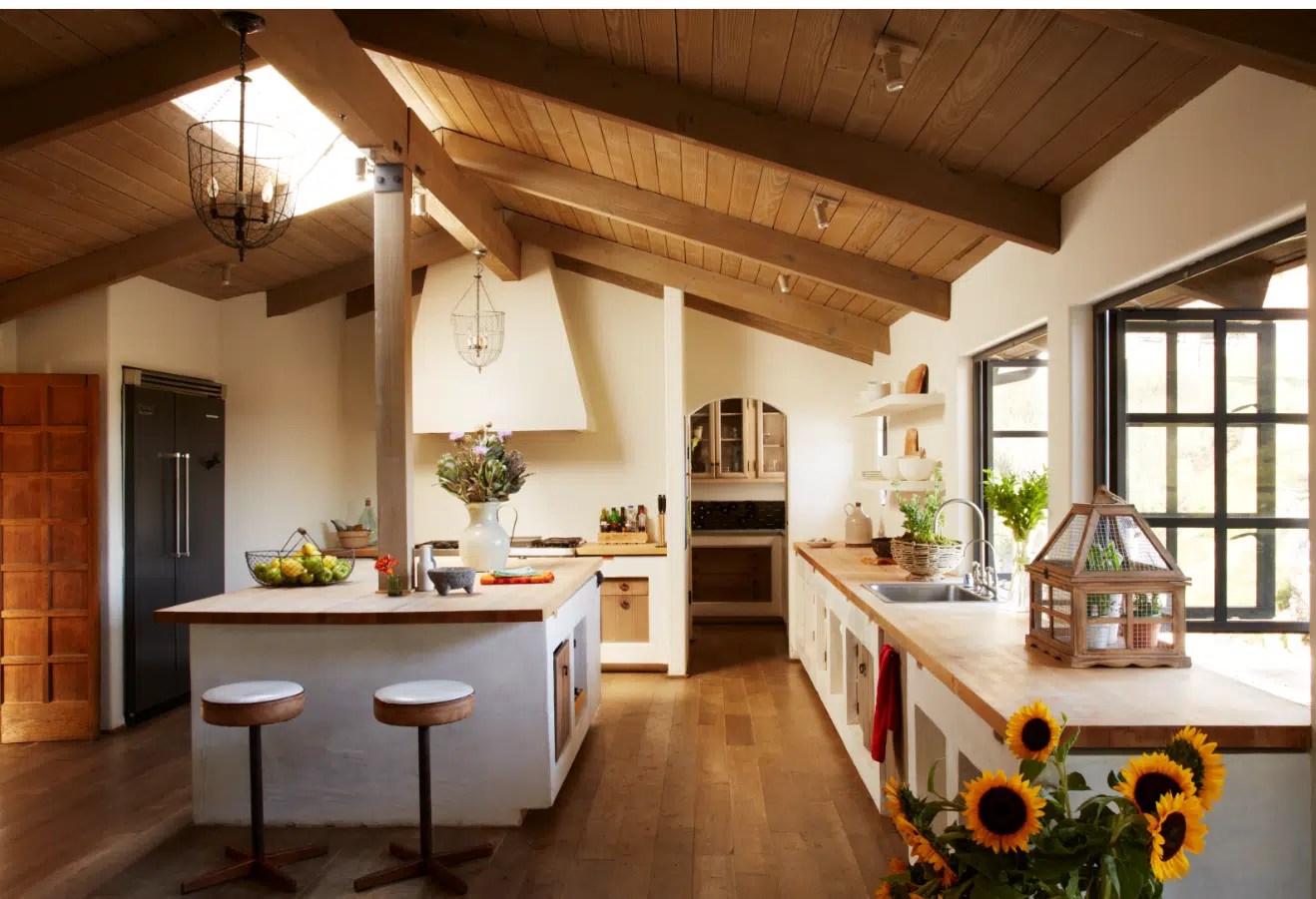 A living room filled with furniture and vase of flowers on a kitchen counter