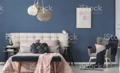 A bedroom with a desk and chair in a room