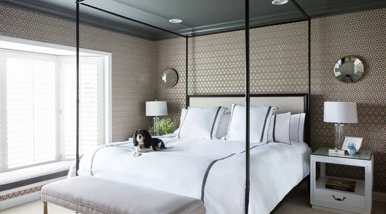 A bedroom with a bed and desk in a hotel room