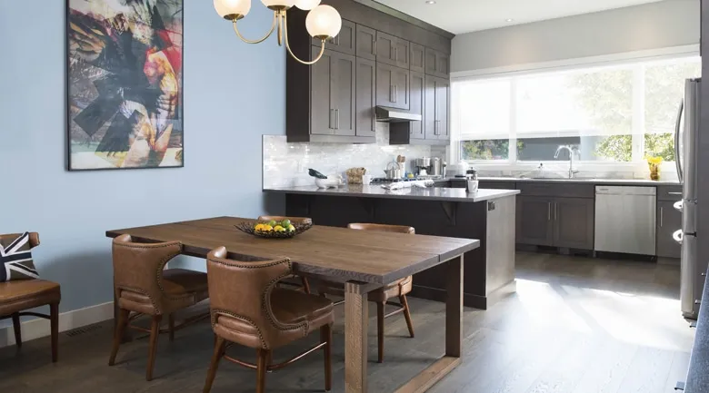 A kitchen with wooden cabinets and a dining room table