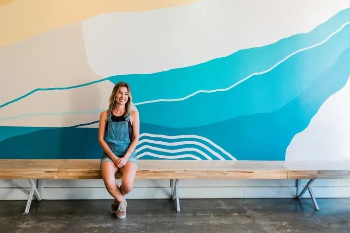 A person standing in front of a blue bench