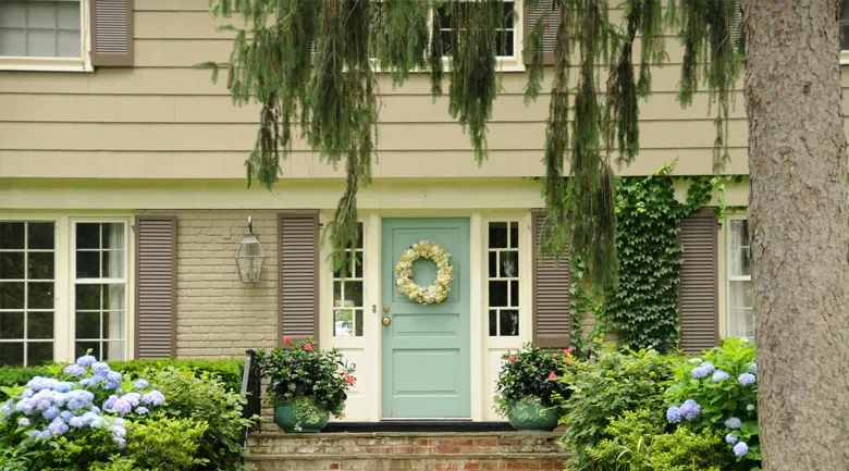 A house with bushes in front of a brick building