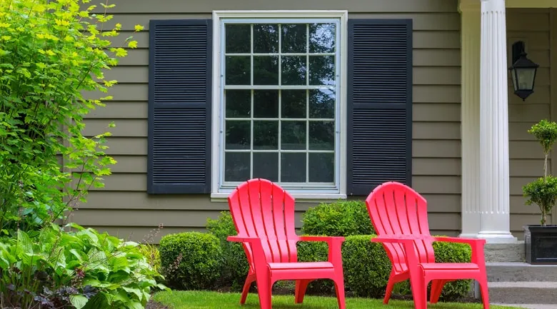 A couple of lawn chairs sitting on a bench in front of a building