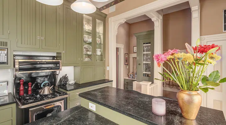 A room filled with furniture and vase of flowers on a kitchen counter