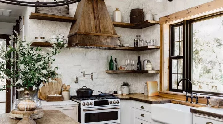 A kitchen with a stove top oven sitting next to a window