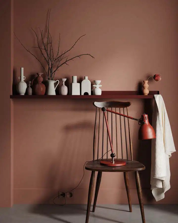 A vase of flowers is sitting on the corner of a room