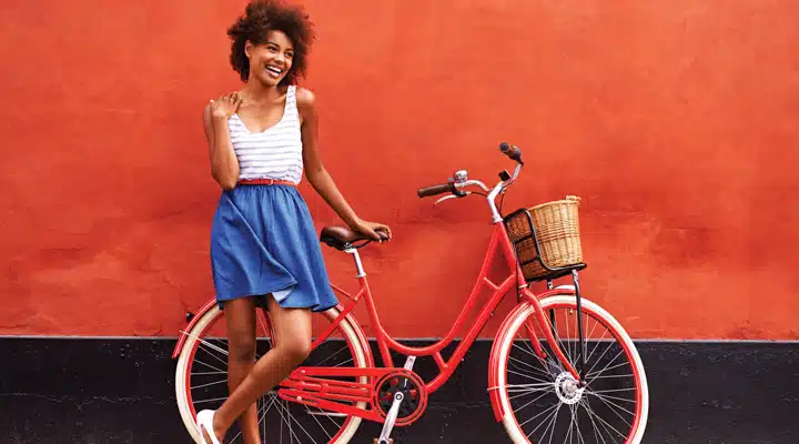 A woman standing in front of a bicycle